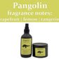 A candle and a room spray, both in matte black vessels with yellow labels featuring pangolins, sit in front of a bright white background. A yellow header describes the fragrance as a combination of grapefruit, lemon, yuzu, and tangerine. 